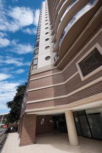 a tall building with a blue sky in the background at Fiori Apartments in Sydney