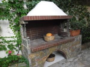 un horno de ladrillo con una cesta de fruta. en Litsa, en Plomari