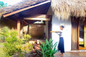 a woman standing in front of a house at Nanas Homestay in Gili Islands