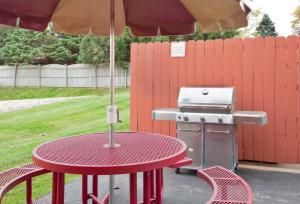 a picnic table with an umbrella next to a grill at Candlewood Suites Rockford, an IHG Hotel in Rockford