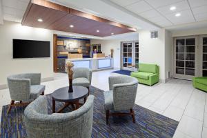 a lobby with chairs and a table and a tv at Holiday Inn Express Hotel & Suites San Diego-Escondido, an IHG Hotel in Escondido