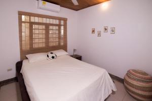 Un dormitorio con una cama con una pelota de fútbol. en Cabaña Badelandia, en Coveñas