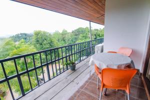 a balcony with a table and orange chairs on it at Blue Haven Hotel in Kandy +28 photos