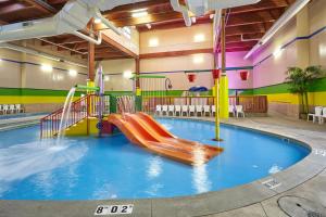 a swimming pool with a slide in a building at Holiday Inn Grand Rapids - South, an IHG Hotel in Cutlerville