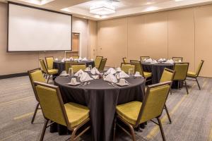 uma sala de conferências com mesas e cadeiras e um ecrã em Holiday Inn Joplin, an IHG Hotel em Joplin