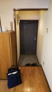 a hallway with a black door and a bag on the floor at Cherry Blossom Koseicho in Okayama +8 photos