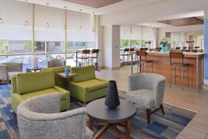 a lobby with chairs and tables and a bar at Holiday Inn Express & Suites Buffalo Downtown, an IHG Hotel in Buffalo