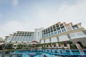 a hotel with a swimming pool in front of a building at Ancasa Royale, Pekan Pahang by Ancasa Hotels & Resorts in Pekan