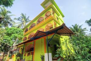 a yellow house with a roof on top of it at Richard Inn Residency in Calangute