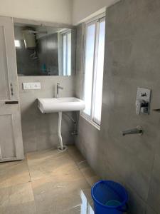 baño con lavabo y ventana en Hideout Backpackers Hostel en Darjeeling
