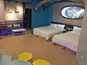 een hotelkamer met 2 bedden en een rond raam bij Starry Laurel in Magong