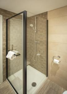 a shower with a glass door in a bathroom at Hôtel Mont-Brison in Briançon