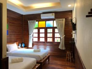 um quarto com 2 camas e uma janela com um arco-íris em Chiangkhan Hotel em Chiang Khan