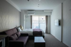 a hotel room with a couch and a bed at Marina Sunrise Osaka Bay in Osaka