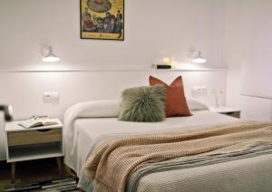 a bedroom with a bed with pillows and a table at ZUBIGANE apartamento junto a la Ría & Parking in Bilbao