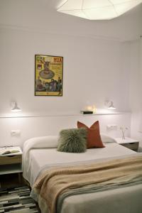 a white bedroom with a large bed with two pillows at ZUBIGANE apartamento junto a la Ría & Parking in Bilbao