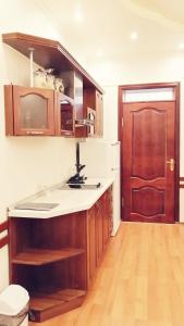 a kitchen with wooden cabinets and a sink and a door at Continental Hotel in Rostov on Don