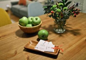 una mesa con un plato de manzanas y un tazón de flores en ZUBIGANE apartamento junto a la Ría & Parking en Bilbao