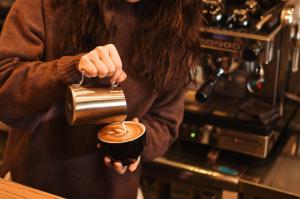 a woman is pouring coffee into a cup at Hotel Pacific Kanazawa in Kanazawa