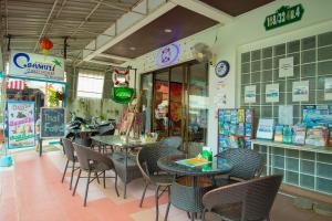 una sala da pranzo con tavoli e sedie in un ristorante di C.Samui Guesthouse a Lamai Beach