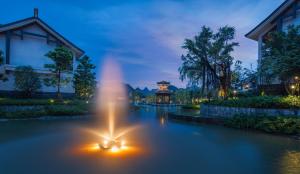 a fountain in the water in front of a building at Banyan Tree Yangshuo in Yangshuo