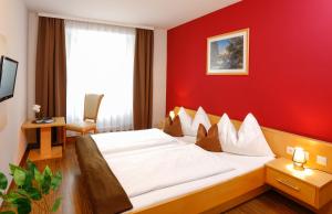拉德施塔特的住宿－森德爾霍夫酒店，酒店客房,设有床铺和红色的墙壁
