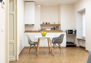 a kitchen with a table and two chairs at aqualago casa vacanze apartment E in Verbania +9 photos