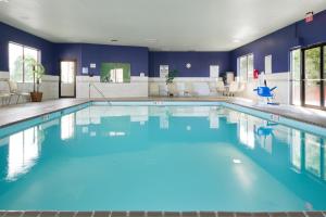 una gran piscina con agua azul en una habitación de hotel en Holiday Inn Express Louisville Northeast, an IHG Hotel, en Louisville