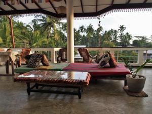 a patio with a bed and chairs and a table at Disna Place in Unawatuna