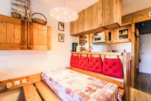 um quarto com uma cama vermelha num quarto em Les Arcs 1800, Nova 2, 6 pers, Parking couvert gratuit em Arc 1800