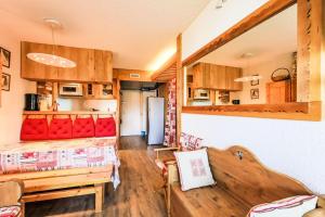 ein Wohnzimmer mit einem roten Sofa und einem Kühlschrank in der Unterkunft Les Arcs 1800, Nova 2, 6 pers, Parking couvert gratuit in Arc 1800