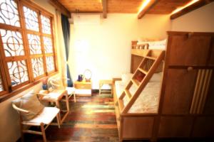 Zimmer mit 2 Etagenbetten und einem Fenster in der Unterkunft Begonia Flowers Guesthouse in Suzhou