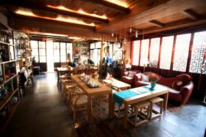 a restaurant with tables and couches and windows at Begonia Flowers Guesthouse in Suzhou