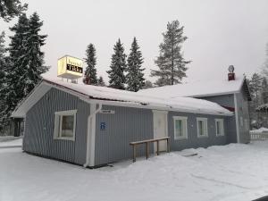 Un bâtiment avec un panneau en haut dans la neige dans l'établissement Hostel Tikka, à Rovaniemi