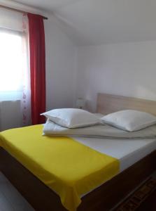 a bed with a yellow blanket and two pillows at Casa Maria in Vatra Dornei
