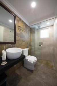 a bathroom with a sink and a toilet and a mirror at Ancasa Resort Port Dickson in Port Dickson