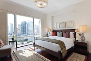a bedroom with a large bed and a large window at Raffles Makati in Manila