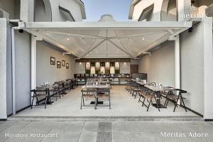 a restaurant with tables and chairs in a building at Meritas Adore Resort in Lonavala