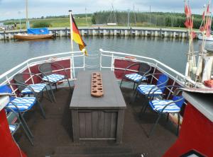a table and chairs on a boat in the water at Bülows Ferienwohnung mit 2 Schlafzimmern in Klein Zicker