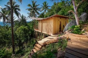 a small wooden cabin with a view of the ocean at Ecotao Lodge in Ko Tao
