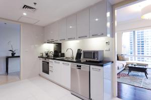 a kitchen with white cabinets and a microwave at Raffles Makati in Manila