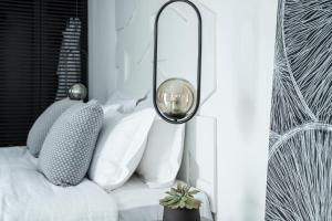 a room with white pillows and a lamp at Nimbus Mykonos in Agios Stefanos