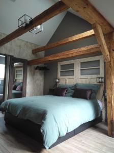 a bedroom with a large bed with wooden beams at B&B Landhof Schober in Weissbriach