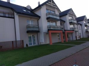 a row of houses with a lawn in front of them at Apartament BLUE BAY Darłówko in Darlowko