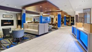 a lobby of a hotel with chairs and tables at Holiday Inn Express & Suites Medina, an IHG Hotel in Medina