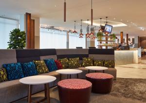 um lobby com um sofá e duas mesas e ools em Holiday Inn Express Newcastle, an IHG Hotel em Newcastle