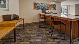a bar in a hotel room with two stools at Holiday Inn Express Louisville Airport Expo Center, an IHG Hotel in Louisville
