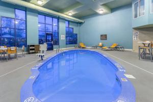 a large swimming pool in a room with tables and chairs at Holiday Inn Express Scottsburg, an IHG Hotel in Scottsburg