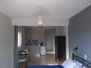 a bedroom with a bed and a kitchen with a table at Rodanthy II in Katelios