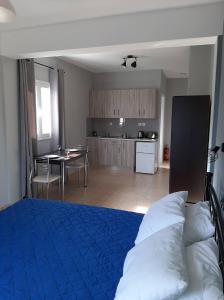 1 Schlafzimmer mit einem blauen Bett und einer Küche in der Unterkunft Rodanthy II in Kateliós